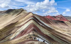travelers in front of vinicunca rainbow mountain